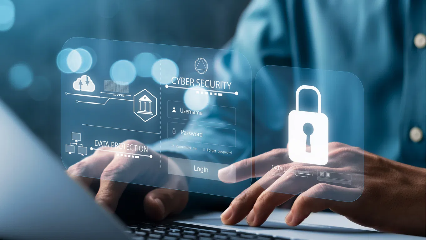 cybersecurity Person typing on a laptop with a digital hologram interface showing cybersecurity login, data protection, and lock icons symbolizing online security.